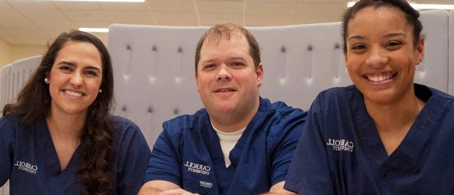 三位面带微笑的医护人员穿着印有威尼斯游戏大厅标志的消毒服.